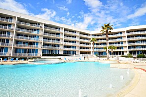 Un hotel con varios balcones, piscina y palmeras.