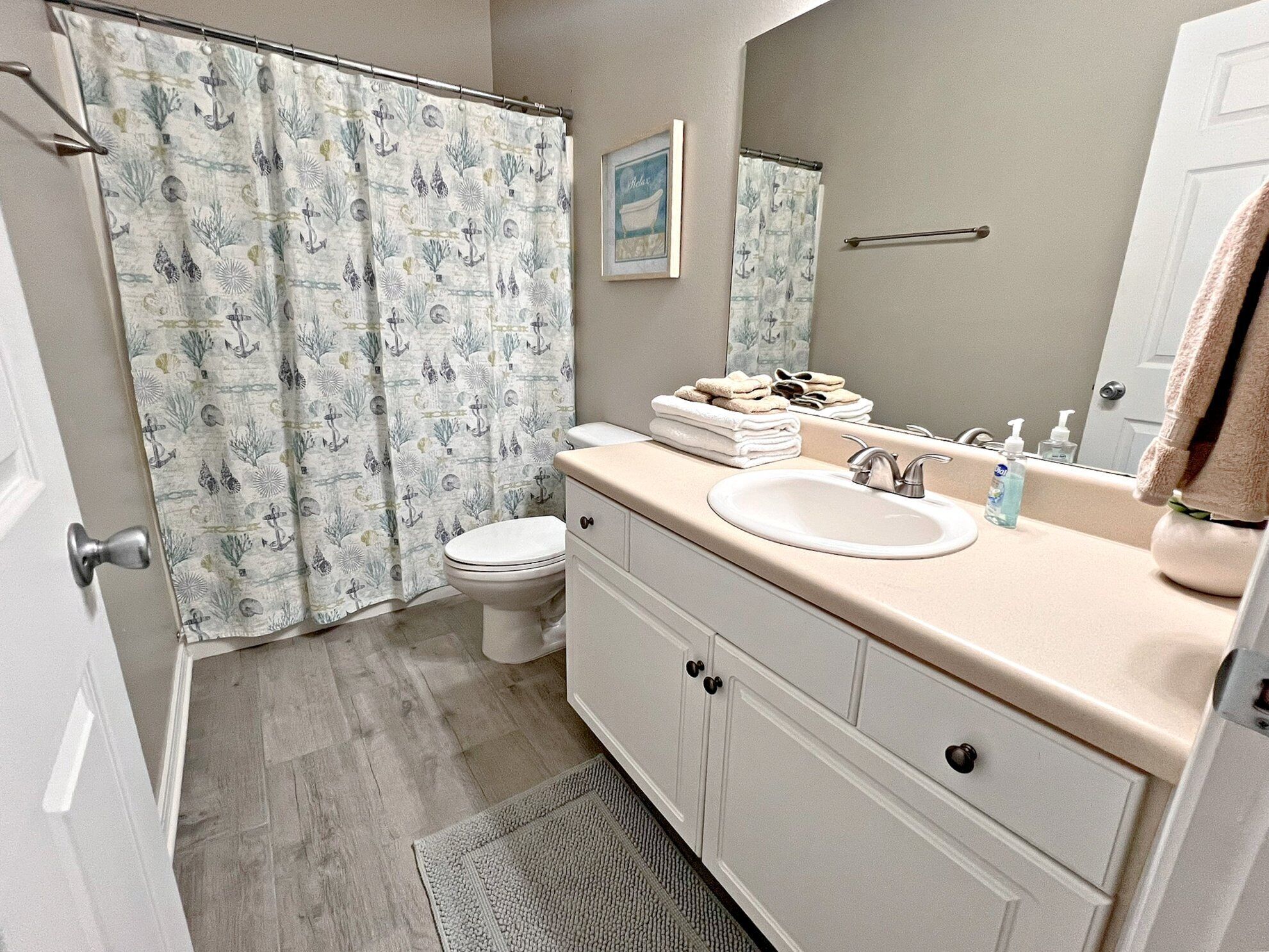 A bathroom with a toilet, sink, and shower curtain.
