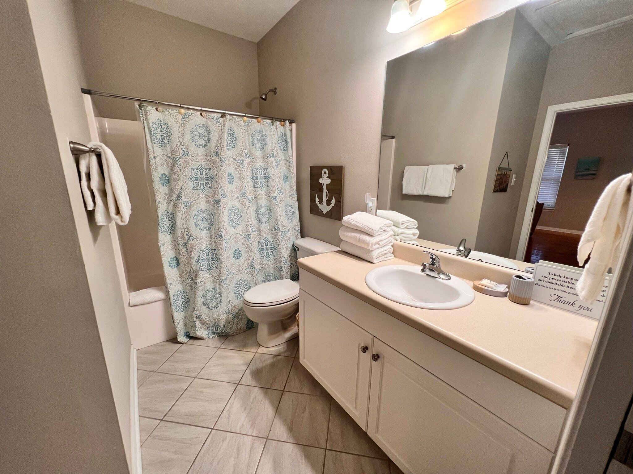 Een badkamer met toilet, wastafel en douchegordijn.