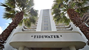 A building with the sign 'Tidewater' at the entrance, surrounded by palm trees. - Tidewater (Orange Beach)