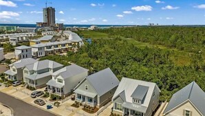 Zona residencial com casas modernas, um edifício em construção e vista para o oceano.