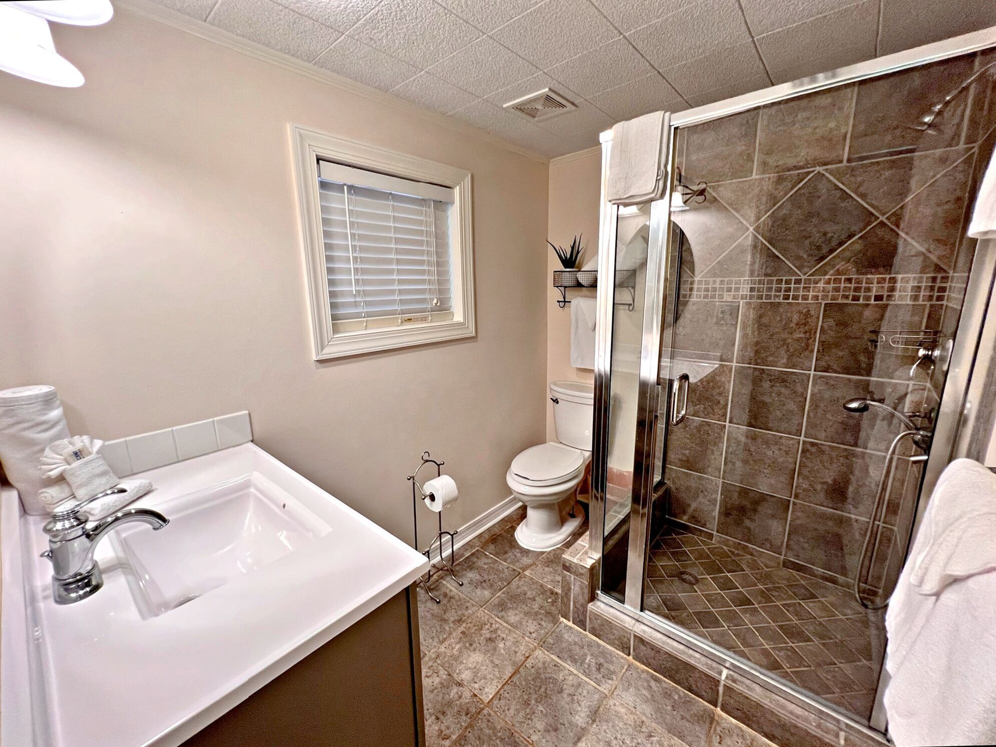 Une salle de bain équipée d’une baignoire, de toilettes et d’une cabine de douche en verre.