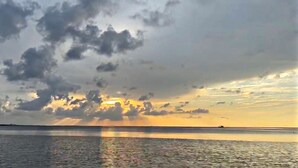 A sunset over a body of water with clouds in the sky. - Porpoise Pass - Ground Floor Guest Suite (Foley)