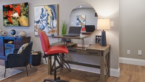 Ein moderner Arbeitsraum mit einem Holztisch, einem roten Bürostuhl und zwei Laptops.