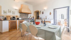 A spacious kitchen with a dining area, featuring a large island, modern appliances, and a view into the dining room. - Le Napoléon - Appt à moins d'un km de la plage (L'Île-Rousse)