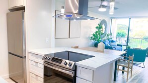 Een moderne keuken met een inbouwoven, kookplaat en een roestvrijstalen koelkast.