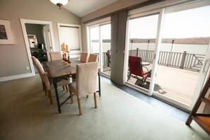 A dining area with a table and chairs, a sliding glass door leading to a balcony with a railing.