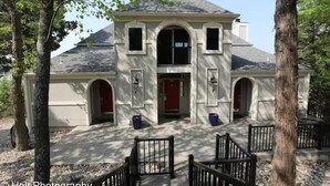 A building with a symmetrical facade, arched windows, and a central entrance. - Stunning Lake View 4br 5ba (Osage Beach)