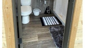 Ein kleines Badezimmer mit Toilette, Waschbecken und Spiegel.