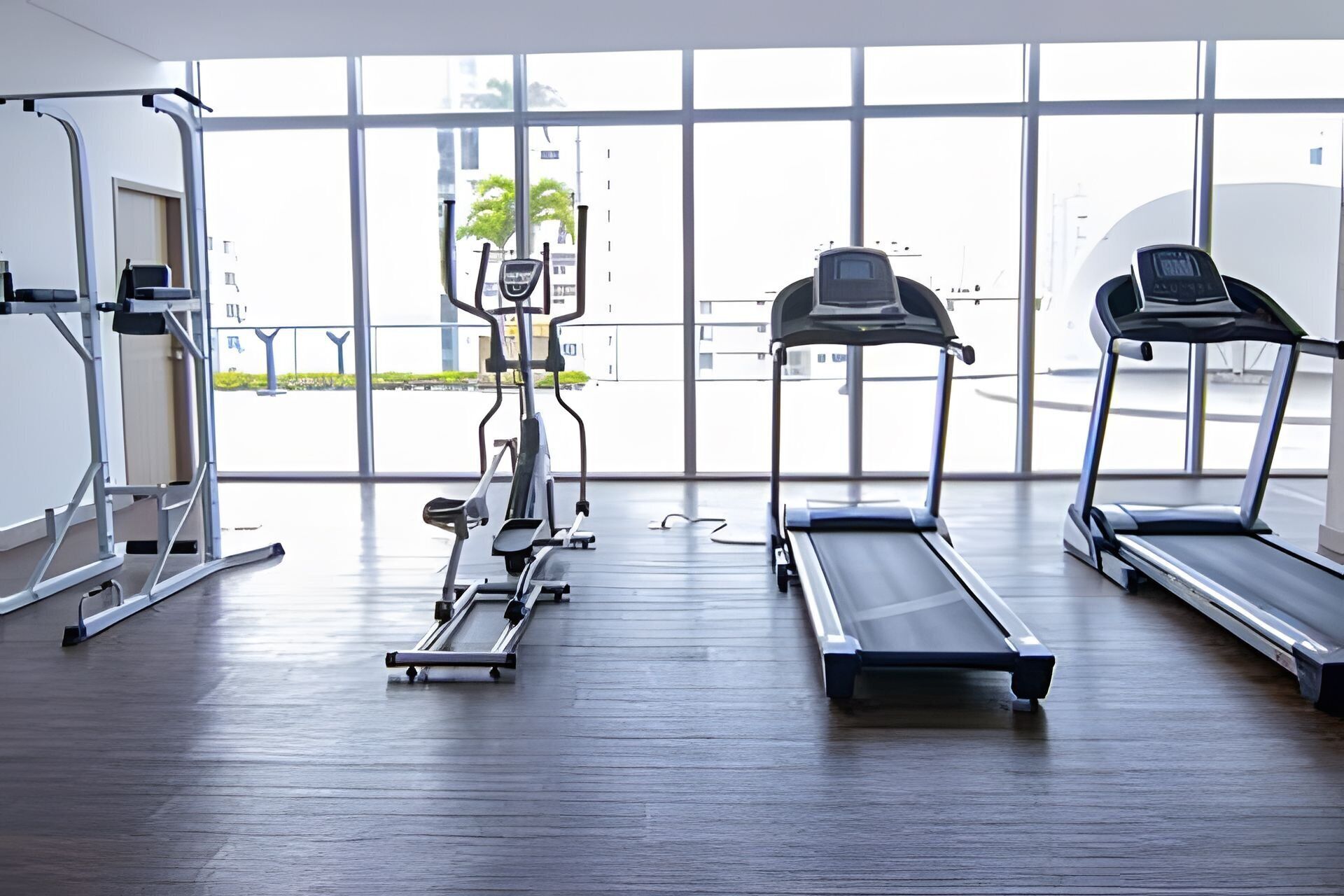 A gym with treadmills, an elliptical machine, and weightlifting equipment.