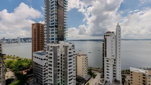 A high-rise building with multiple floors, a view of the sea, and a cloudy sky. - 16th Floor Infinitum 1 Bedroom Apt (Cartagena)