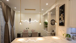 A modern dining area with a marble table, pendant lights, and a dining set. - Luxury Townhome Minutes From DC (Alexandria)