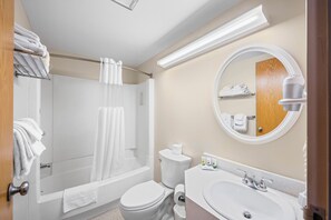 A modern bathroom with a shower, toilet, sink, and a mirror.