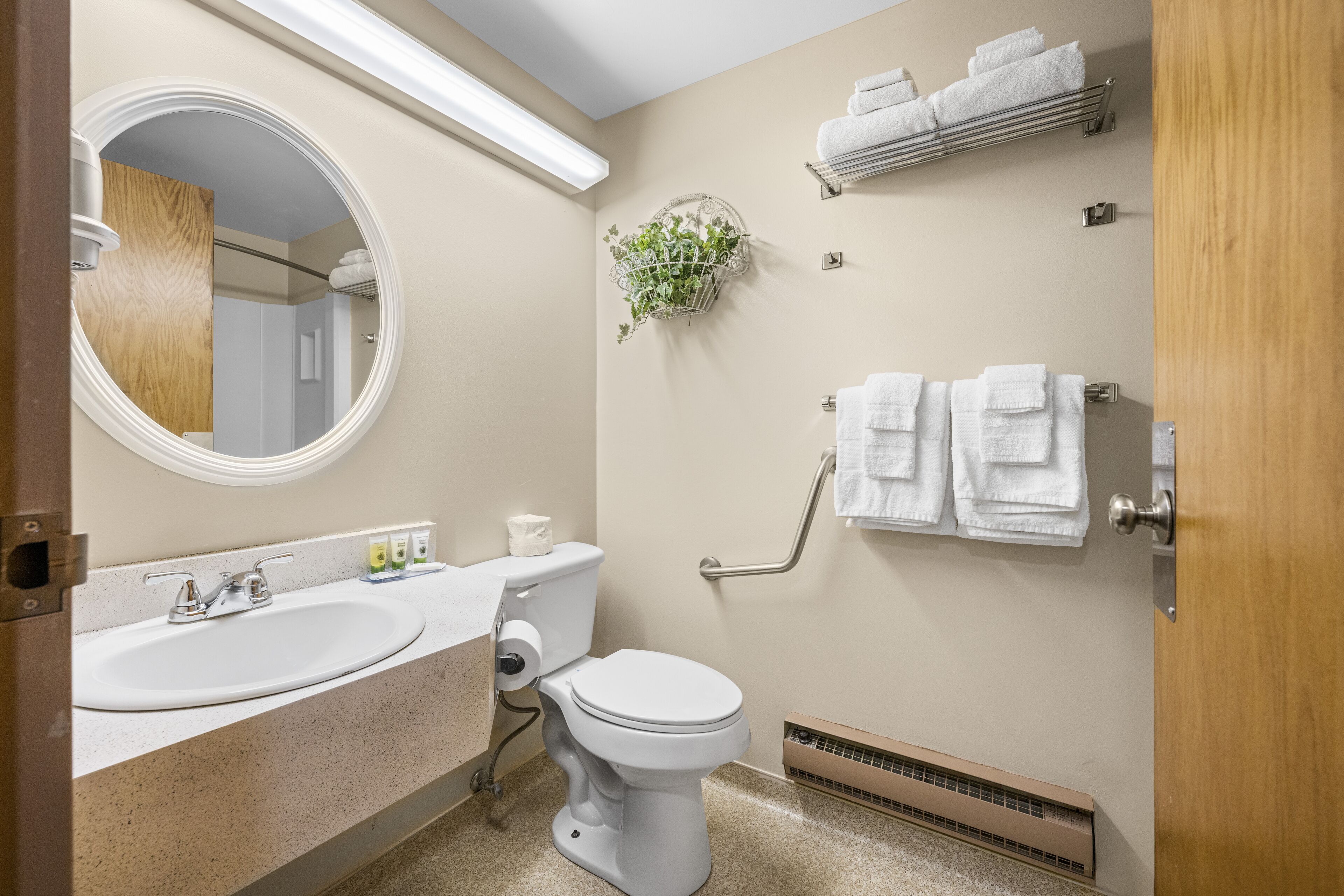 Un baño con lavamanos, inodoro y toallero.