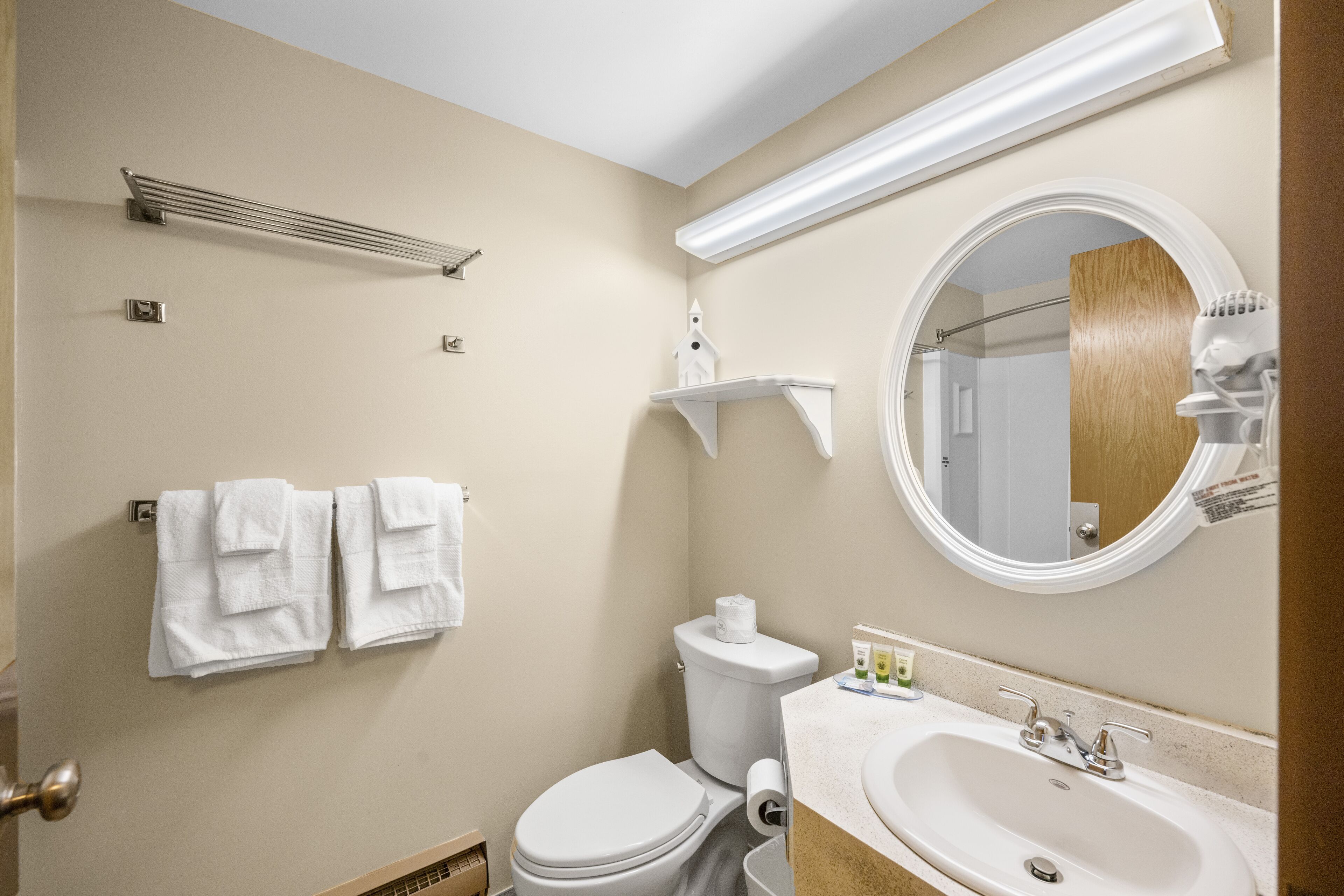 A bathroom with a toilet, sink, and towel rack.