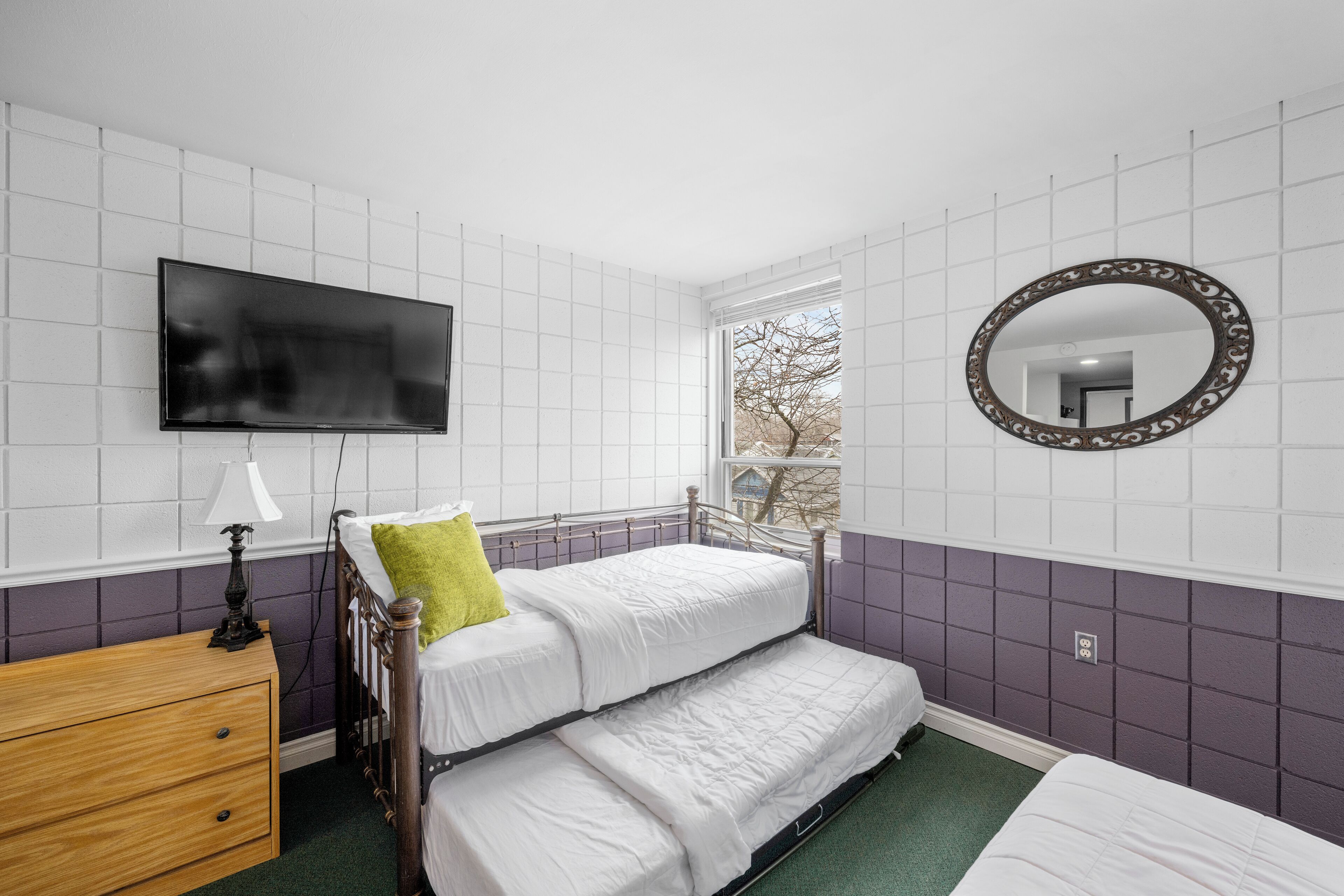 A room with a bed, a dresser, a TV, and a window.