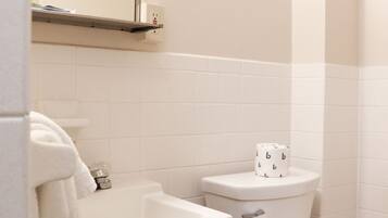 A bathroom with a white sink, toilet, and mirror.