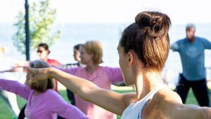 A group of people practicing yoga outdoors on mats. - The Fountain Inn (Marblehead)