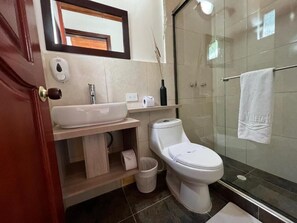 A modern bathroom with a glass shower enclosure, a white sink, and a toilet. - Villeta Resort Hotel (Villeta)