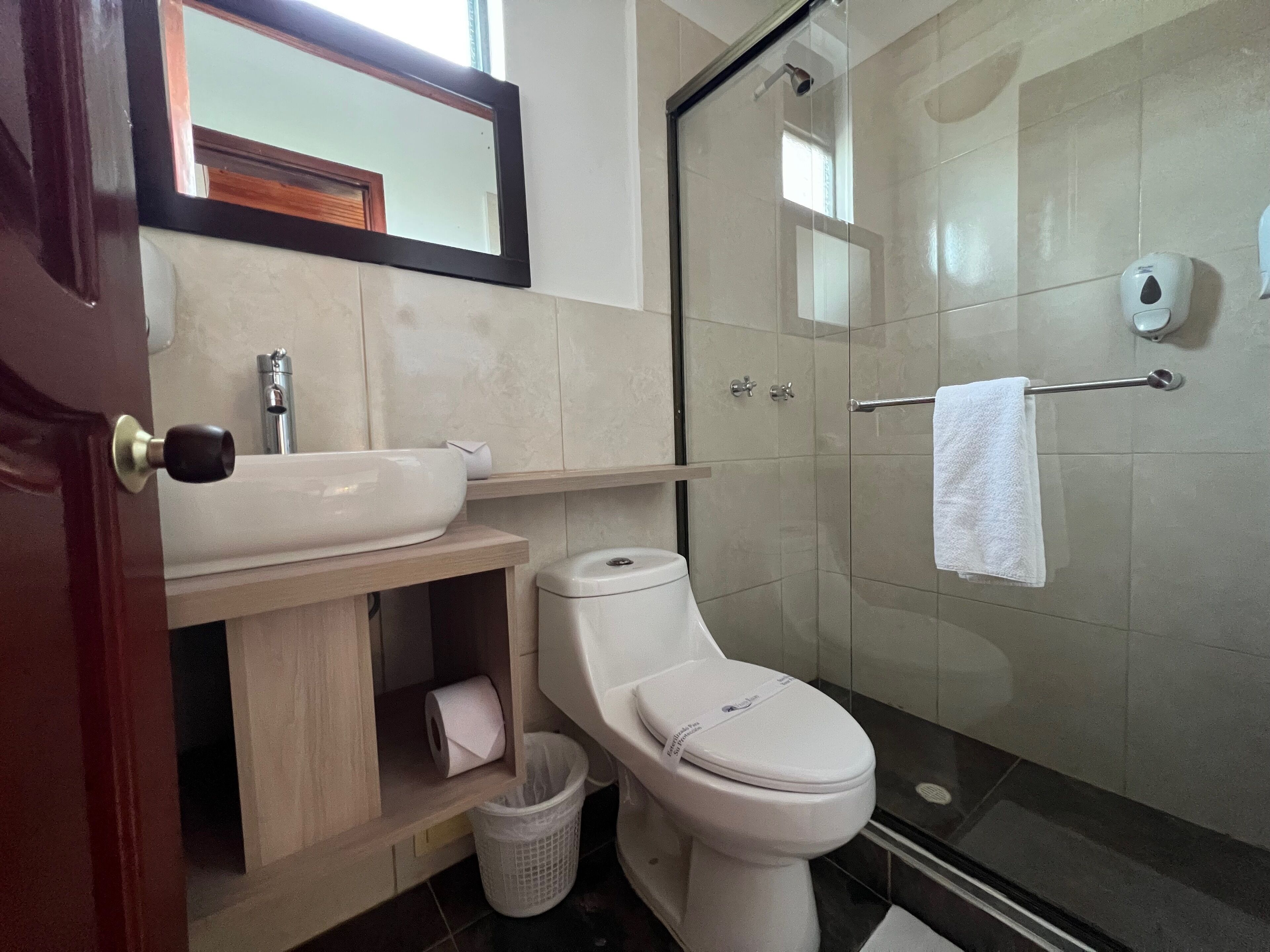 Un baño con inodoro, lavamanos y ducha.