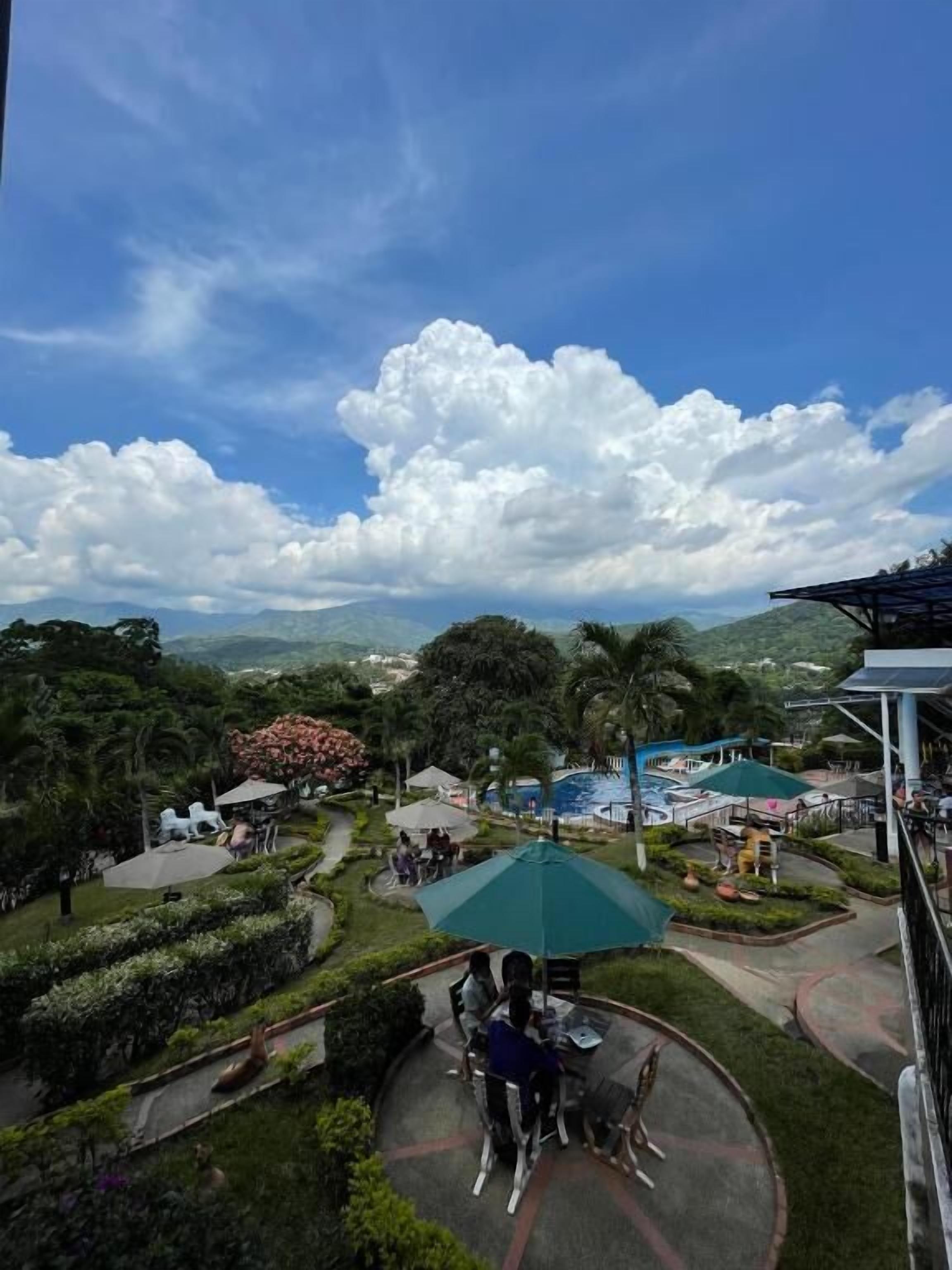 Un resort con piscina, mobiliario exterior y vistas a las montañas.
