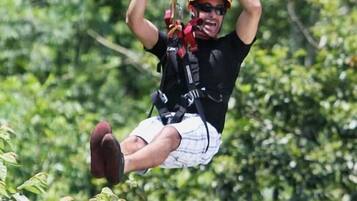 A person ziplining through a forest.