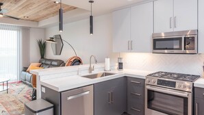 Une cuisine moderne équipée d’une cuisinière à gaz Bosch, d’un four à micro-ondes et d’un évier.