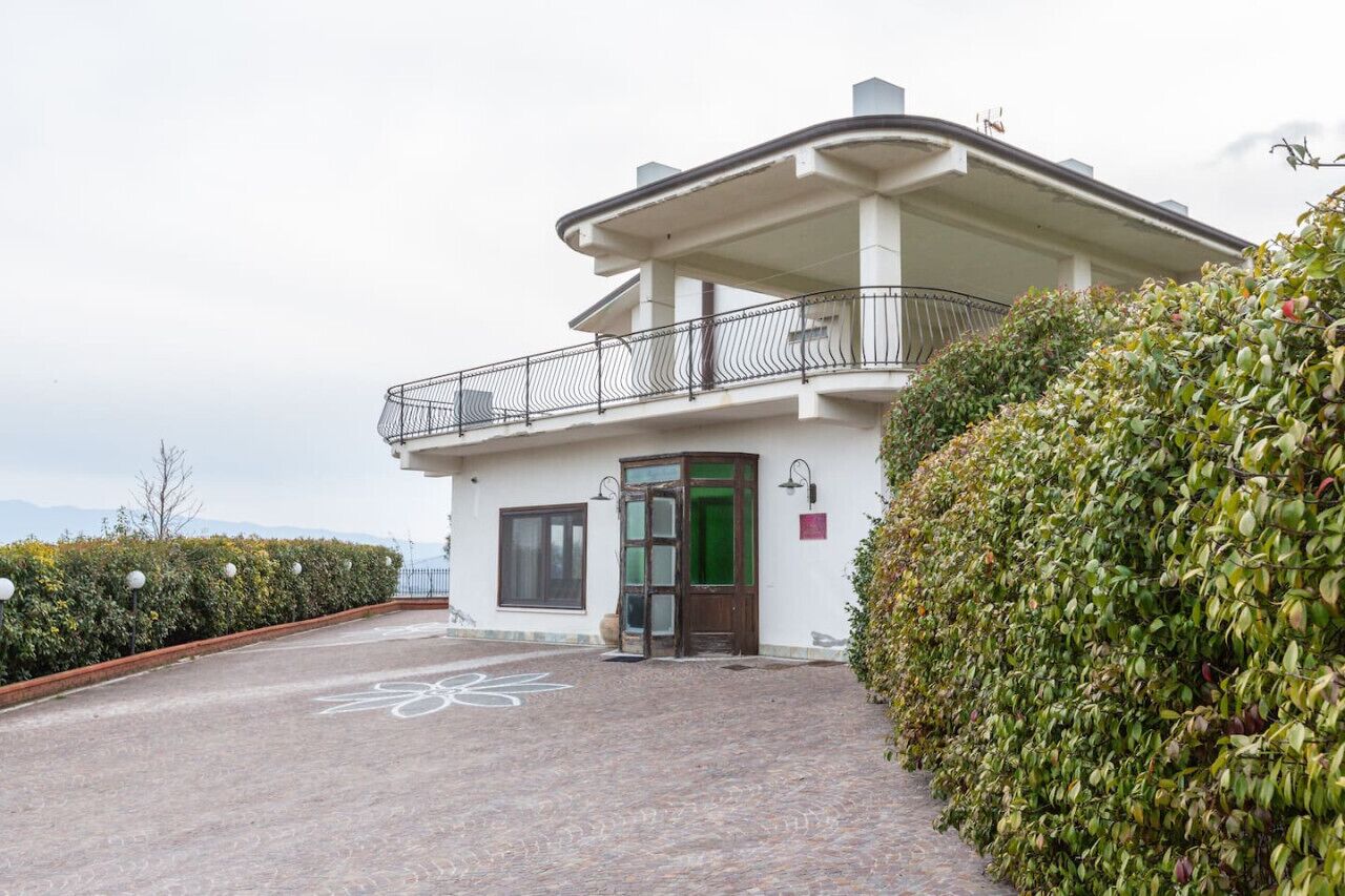 A two-story building with a balcony, a door, and a window.