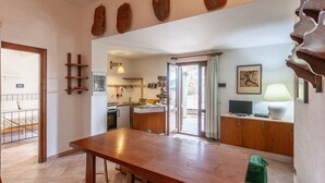 Eine moderne Küche mit Essbereich, Holzmöbel und Blick auf den Garten.