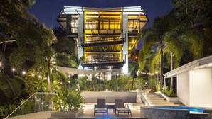 A modern multi-story building with a pool and outdoor seating area. - Zen Jungle Oasis ~ Infinity Pool ~ Stunning Views (Quepos)