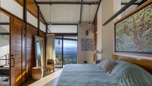 A bedroom with a large bed, a view of the outdoors, and a wooden ceiling. - Zen Jungle Oasis ~ Infinity Pool ~ Stunning Views (Quepos)