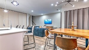 Un salon moderne avec un canapé, une table à manger et un téléviseur.