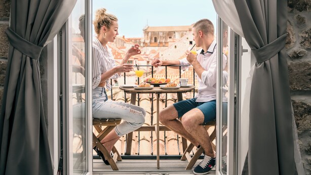 A couple dining at a table with a view of a historic building.