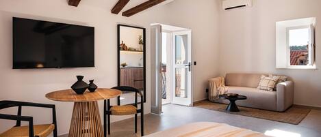Une chambre d’hôtel moderne avec un grand lit, une télévision, une table en bois et un canapé.