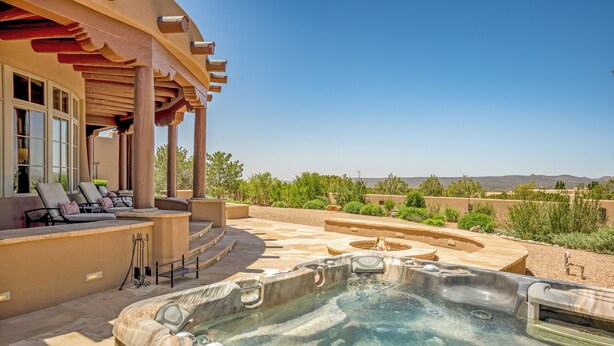 A hot tub area with a pool, outdoor seating, and a view of the landscape. - Villa Campanas | Luxury Home with Mountain Views (Santa Fe)