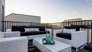 A rooftop terrace with white wicker furniture, a black sofa, and a tray with bottles. - 2 Lux Homes, 8 bedrooms/28 beds! Baller Game Room (Nashville)