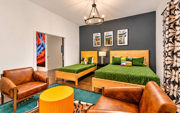 A hotel room with a bed, two bedside tables, a lamp, a chair, and a sofa.