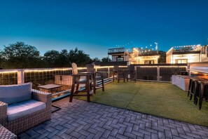 A rooftop patio with outdoor furniture, a small pool, and a view of the city skyline at dusk. - Luxury Home Amazing Rooftop 11 Beds Pool Table! (Nashville)