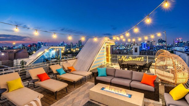 A rooftop bar with outdoor seating, a fire feature, and a city skyline view. - Premium Gulch Home 15 Beds Ultimate Skyline Views (Nashville)