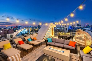 A rooftop bar with outdoor seating, a fire feature, and a city skyline view. - Premium Gulch Home 15 Beds Ultimate Skyline Views (Nashville)