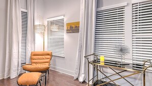 A room with a two-seater sofa, a small table with a lamp, and a window with blinds. - Premium Gulch Home 15 Beds Ultimate Skyline Views (Nashville)