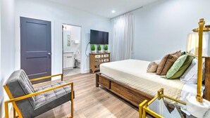 A bedroom with a bed, a chair, a dresser, a TV, and a window with curtains. - Huge Lux Home Rooftop Views + Hot Tub, Pool+Sauna! (Nashville)