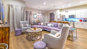 Ein modernes Wohnzimmer mit einer Eckcouch, einem Couchtisch und einem Essbereich mit Tisch und Stühlen.