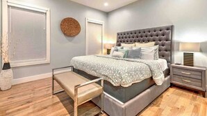A bedroom with a large bed, bedside tables, a bench, and a window with blinds. - Lux Home • 13 Beds • Walk 2 Restaurants • Rooftop (Berry Hill)