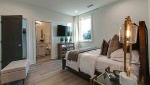 Un dormitorio moderno con cama, mesita de noche y televisión.