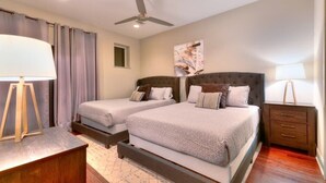A hotel room with two beds, a ceiling fan, a nightstand, and a painting on the wall. - Premiere Gulch Home, 15 Beds! Best Skyline Views! (Nashville)