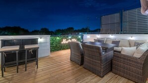 An outdoor patio area with wicker furniture and a neon sign. - Huge Downtown Luxury Home Rooftop Deck 12 Beds (Nashville)