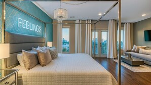 A modern hotel room with a large bed, a city view, a chandelier, and a wall-mounted TV. - Rooftop Pool Table Gulch! City Views! 15 beds! (Nashville)