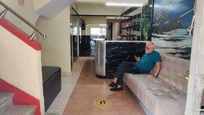 Un vestíbulo de hotel con una escalera, una zona de estar y un gran mural.