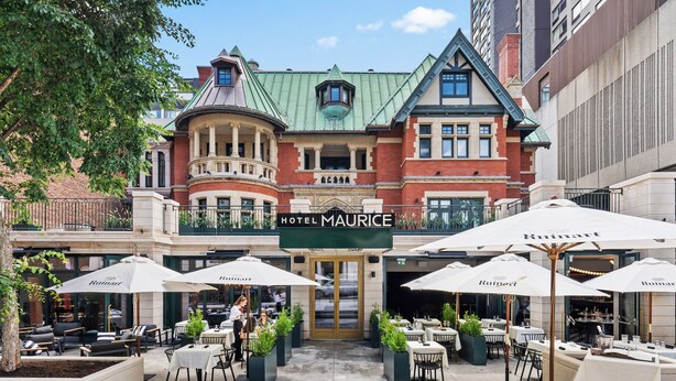 The exterior of Hotel Maurice with outdoor seating and a green roof. - Hotel Maurice (Québec City)